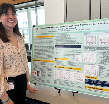 Student stands with presentation poster board