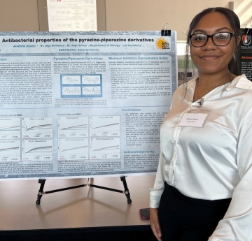 Student stands with presentation poster board
