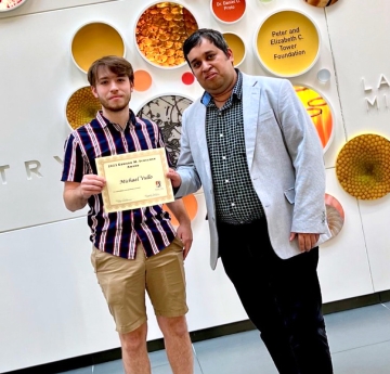 Student and faculty member holding a certificate